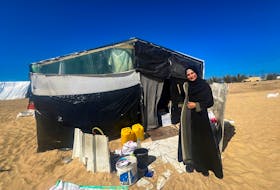 Inas Al-Baz, a displaced teacher from Beach refugee camp in Gaza City, poses for a picture outside her tent, in Rafah, in the southern Gaza Strip February 21, 2024.
