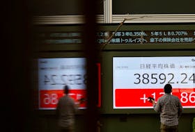 A man looks at an electronic screen displaying Japan's Nikkei share average outside a brokerage in Tokyo, Japan February 20, 2024. 