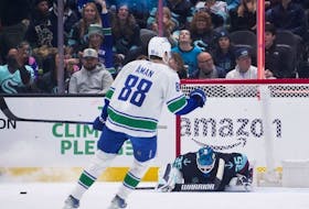 Seattle Kraken goaltender Joey Daccord looks down after allowing a goal to Canucks centre Teddy Blueger, as centre Nils Aman (88) reacts during a game in November.