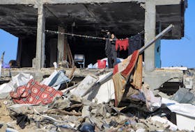 A Palestinian hangs clothes next to a destroyed building, amid the ongoing conflict between Israel and Hamas, in Jabalia refugee camp, in the northern Gaza Strip February 22, 2024.