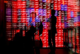 Visitors and electronic screens displaying Japan's Nikkei stock quotation board are reflected on window glasses as the share average surged past an all-time record high scaled in December 1989, inside a building in Tokyo, Japan February 22, 2024. 