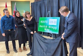 The family of Derrick Bragg (left) and Premier Andrew Furey (right) unveil a new highway sign that will be erected in the late cabinet minister’s memory. -Juanita Mercer/SaltWire