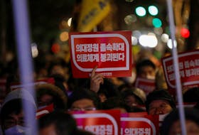 A doctor holds a slogan in a protest against a plan to admit more students to medical school, in front of the Presidential Office in Seoul, South Korea, February 22, 2024.