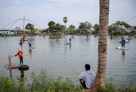People fish in a pond on the outskirts of Buriram province, Thailand, January 28, 2024.