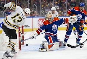 Goaltender Stuart Skinner (74) of the Edmonton Oilers makes a save against Charlie Coyle (13) of the Boston Bruins at Rogers Place on Wednesday, Feb. 21, 2024, in Edmonton.