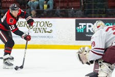 UNB Reds forward Benjamin Corbeil fires a shot on Saint Mary's Huskies goalie Jeremy Helvig during Game 1 of their AUS hockey semifinal Friday in Fredericton - UNB Athletics