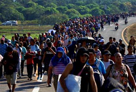 Migrants walk in a caravan towards the U.S. border, in Huixtla, Mexico, January 26, 2024.