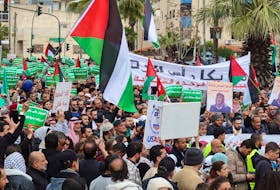 Demonstrators carry flags and banners during a protest in support of Palestinians in Gaza, amid the ongoing conflict between Israel and the Palestinian Islamist group Hamas, in Amman, Jordan February 23, 2024.