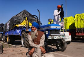 A farmer ties a black flag on his tractor at the site of a protest as they march towards New Delhi to push for better crop prices promised to them in 2021, at Shambhu Barrier, the border between Punjab and Haryana states, India February 23, 2024.