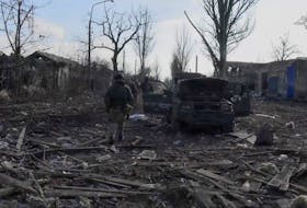 Members of the Russian military walk amid the rubble, near a damaged car, in a location given as Avdiivka, Ukraine, in this screen grab obtained from a social media video released February 22, 2024. Russian Defence Ministry/via REUTERS