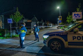 A police officer stands near police tape in Tullinge in Botkyrka, near Stockholm, Sweden, where a shooting took place, according to local media, October 13, 2023. Magnus Lejhall/TT News Agency/via
