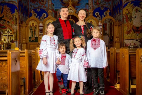 Artem and Liliya Terenyak, rear, with their children, left to right, Yaryna, 9, Ostap, 3, Solomiia, 5, and Taras, 8. They're wearing Ukrainian vyshyvanka, traditional embroidered clothing, for a photo at the Ukrainian Orthodox Cathedral on Saturday.