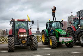 French farmers of the Coordination Rural (CR) use their tractors during a go-slow operation on the Pont Mirabeau bridge with the Eiffel Tower in the background as they protest ahead of the opening of the Paris farm show, in Paris, France, February 23, 2024.