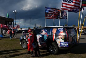 Supporter of former U.S. President and Republican presidential candidate Donald Trump pose in from of a decorated vehicle ahead of his South Carolina Republican presidential primary election night party in Columbia, South Carolina, U.S. February 24, 2024.