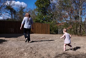 Kristia walks in her yard with her youngest son, born via IVF, in Birmingham, Alabama, U.S., February 23, 2024. Kristia Rumbley of Birmingham used in vitro fertilization to have three children, and has kept two embryos on ice for eight years, just in case she wants another. But an Alabama supreme court ruling that embryos are children cast doubt over the future legality of the procedure in the state, and prompted Rumbley to start planning to ship her embryos overseas.
