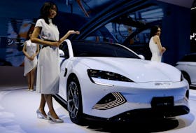 Models pose next to Chinese automobile manufacturer BYD's BYD SEAL during the Japan Mobility Show 2023 at Tokyo Big Sight in Tokyo, Japan, November 1, 2023.