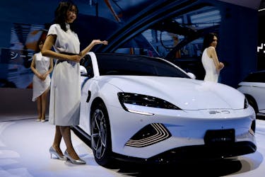 Models pose next to Chinese automobile manufacturer BYD's BYD SEAL during the Japan Mobility Show 2023 at Tokyo Big Sight in Tokyo, Japan, November 1, 2023.