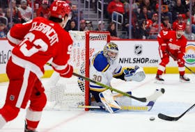 Feb 24, 2024; Detroit, Michigan, USA;  Detroit Red Wings right wing Alex DeBrincat (93) crosses the puck in front of St. Louis Blues goaltender Joel Hofer (30) in the second period at Little Caesars Arena. Mandatory Credit: Rick Osentoski-USA TODAY Sports