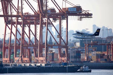 A float plane flies past containers and cranes at the Port of Vancouver, British Columbia, Canada, July 30, 2023.