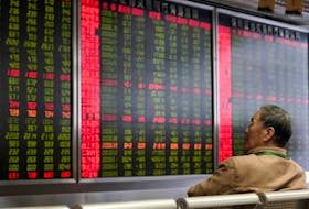 An investor watches a board showing stock information at a brokerage office in Beijing, China October 8, 2018.