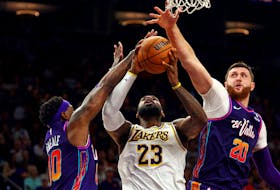 Feb 25, 2024; Phoenix, Arizona, USA; Los Angeles Lakers forward LeBron James (23) shoots the ball against Phoenix Suns forward Royce O'Neale (00) and center Jusuf Nurkic (20) during the fourth quarter at Footprint Center. Mandatory Credit: Mark J. Rebilas-USA TODAY Sports