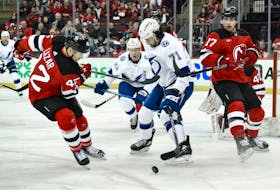 Feb 25, 2024; Newark, New Jersey, USA; Tampa Bay Lightning center Anthony Cirelli (71) tries to gain control of the puck as New Jersey Devils center Curtis Lazar (42) and New Jersey Devils defenseman Simon Nemec (17) defend during the first period at Prudential Center. Mandatory Credit: John Jones-USA TODAY Sports