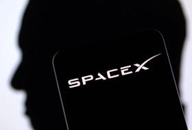 SpaceX logo and Elon Musk silhouette are seen in this illustration taken, December 19, 2022.