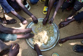 Refugees eat food in the Adre Sudanese refugee camp in Adre, Chad, November 8, 2023.
