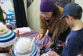 Truro Housing Outreach Director Erika Sullivan brought in a button maker for kids to enjoy during the Coldest Night of the Year festivities on Feb. 24 at the Truro Farmer's Market. Also pictured are Ava Boates, left, Macy Bartlett, centre, and Austin Wood, right. Brendyn Creamer