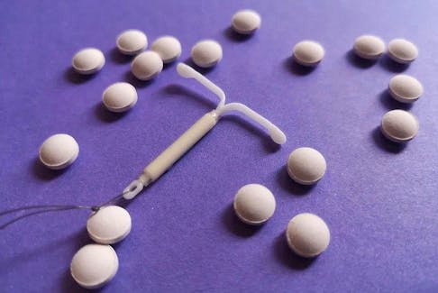  A hormonal IUD surrounded by birth control pills.
