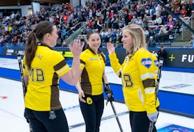 Lead Lauren Lenentine, left, of New Dominion, P.E.I., and skip Jennifer Jones, right, high-five as third stone Karlee Burgess is all smiles after the Manitoba rink won its semifinal game at the Scotties Tournament of Hearts in Calgary on Feb. 25. The rink lost the championship game 5-4 to Ontario’s Rachel Homan. Curling Canada, Andrew Klaver • Special to The Guardian
