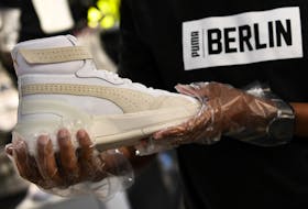 A salesman shows a shoe in the sport store PUMA, as the spread of the coronavirus disease (COVID-19) continues, in Berlin, Germany, April 25, 2020. 