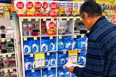 A customer looks at products marked with discounted prices on display at a chemist in a shopping mall in central Sydney, Australia, July 25, 2018.   