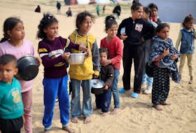 Displaced Palestinian children wait to receive free food at a tent camp, amid food shortages, as the conflict between Israel and Hamas continues, in Rafah in the southern Gaza Strip, February 27, 2024.