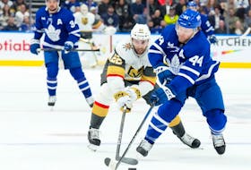 Maple Leafs' Morgan Rielly (right) battles for the puck with Vegas Golden Knights' Michael Amadio during the first period in Toronto, on Tuesday, Feb. 27, 2024.