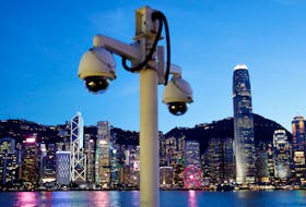 A pair of surveillance cameras are seen along the Tsim Sha Tsui waterfront as skyline buildings stand across Victoria Harbor in Hong Kong, China July 28, 2020.