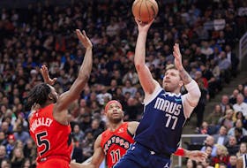 Luka Doncic (77) of the Dallas Mavericks puts up a shot over Immanuel Quickley (5) of the Toronto Raptors in the first half of their NBA game at Scotiabank Arena on Wednesday, Feb. 28, 2024, in Toronto. 