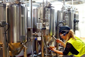 A worker checks beer quality at Anheuser-Busch InBev brewery in Leuven, Belgium November 25, 2019.