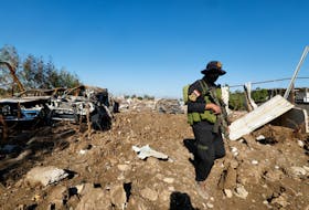 A fighter of the Iraqi Kataib Hezbollah militia group inspects the site of a U.S. airstrike, in Hilla, Iraq December 26, 2023.