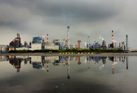 A petrochemical plant is reflected in a puddle at an industrial complex in Kawasaki near Tokyo August 31, 2015.