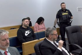 Dominic Delisle (centre) sits in provincial court in St. John's before the start of his sentencing hearing Feb. 28, 2024.