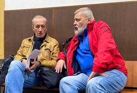 Novaya Gazeta newspaper's editor-in-chief Dmitry Muratov and deputy editor-in-chief Sergei Sokolov sit in a corridor before a court hearing of a case to revoke the newspaper's media license in Moscow, Russia, September 5, 2022.