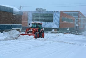 A tractor clears snow piled in front of the James McConnell Memorial Library in Sydney on Saturday morning. Cape Breton is in the midst of an anticipated massive snowfall, with 60-80 centimetres forecasted for much of the island until Sunday evening. Environment Canada has issued a winter storm warning, with conditions on Sunday expected to be especially poor. LUKE DYMENT/CAPE BRETON POST
