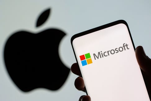 Microsoft logo is seen on the smartphone in front of displayed Apple logo in this illustration taken, July 26, 2021.