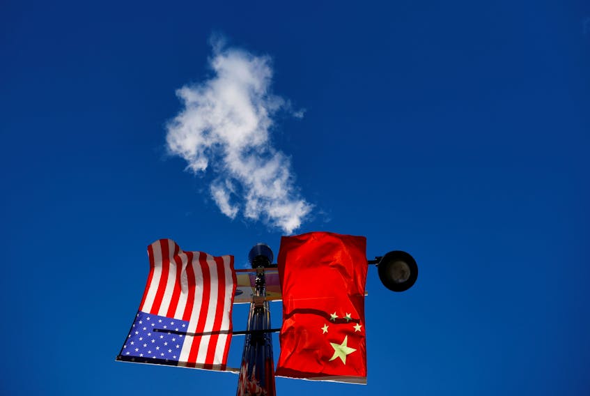 The flags of the United States and China fly from a lamppost in the Chinatown neighborhood of Boston, Massachusetts, U.S., November 1, 2021.  