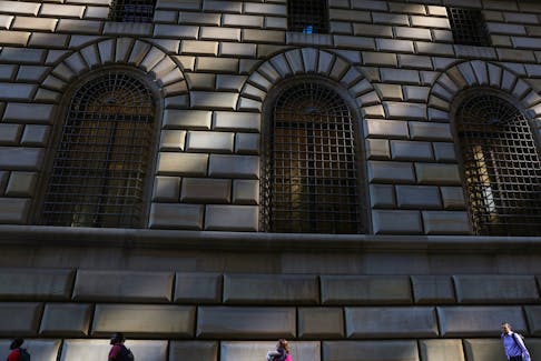 People walk by the Federal Reserve Bank of New York in the financial district of New York City, U.S., June 14, 2023. 