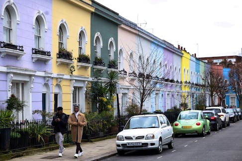 People walk past a row of colourful houses in London, Britain, March 19, 2023.