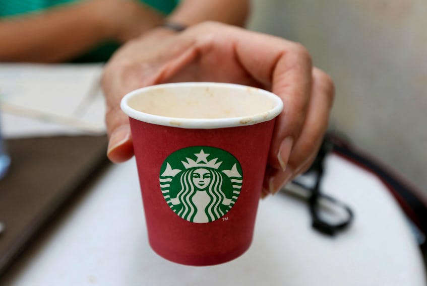 A woman displays a red Starbucks cup at a Starbucks cafe in Beirut, Lebanon November 20, 2016.