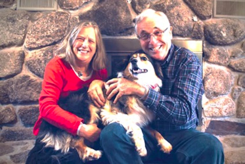 Andrea and Garry Leeson sit by the fireplace with their dog Tilly in their Annapolis Valley home. Contributed