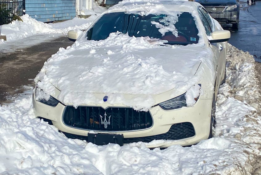 A Maserati is shown stuck in a snowbank.